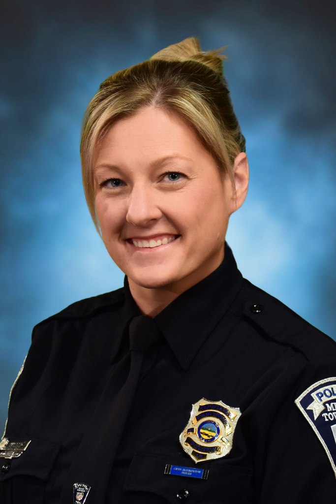 A portrait of Officer Staci Dold in front of a blue background.